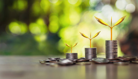 coins stack with step growing plant and sunshine background. concept saving moneyの写真素材