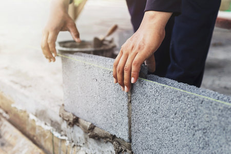 Construction workers are building cement walls with brick blocks.の写真素材
