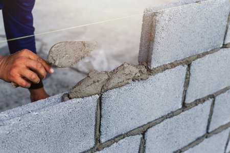 Construction workers are building cement walls with brick blocks.の写真素材