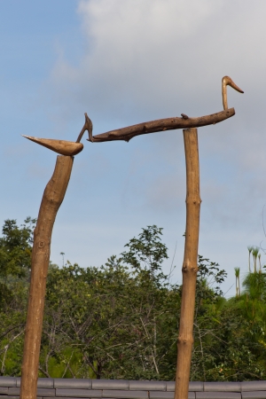 Fake Wooden Birds on the wooden pole with blue sky background.の写真素材