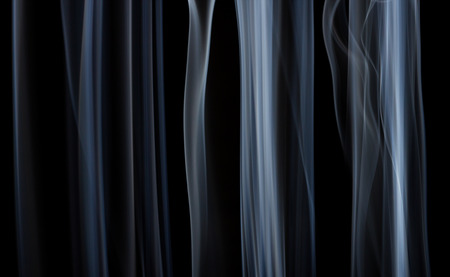 Abstract white smoke floating on dark backgroundの写真素材