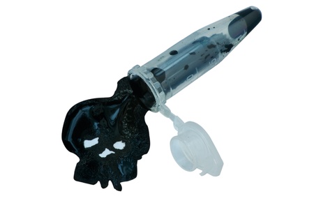 Spilling vial, black skull liquid formed, on white backgroundの写真素材