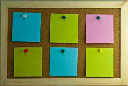 Six post-it notes with pins on cork boardの写真素材
