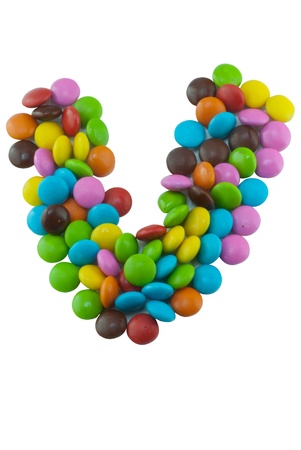 Colorful candies lay in letter V on white backgroundの写真素材
