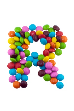 Colorful candies lay in letter R in front of white backgroundの写真素材