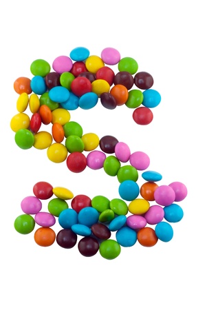 Colorful candies lay in letter S in front of white backgroundの写真素材