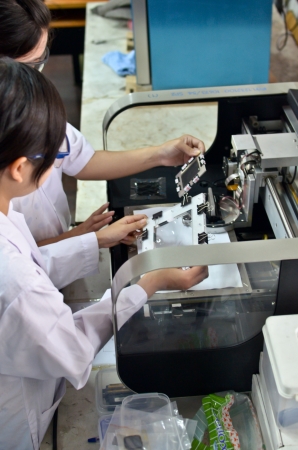Two young researchers using an apparatus in a laboratory.のeditorial素材