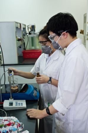 Two young researchers using an apparatus in a laboratory.のeditorial素材