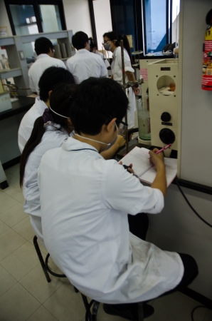 Two young researchers using an apparatus in a laboratory.のeditorial素材