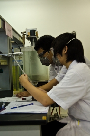 Two young researchers using an apparatus in a laboratory.のeditorial素材
