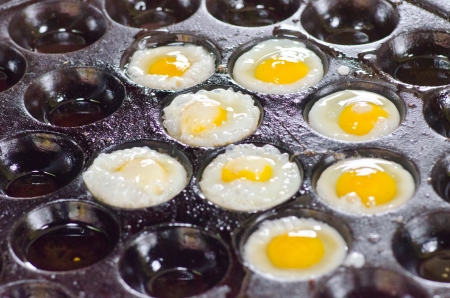 Fried Quail's egg in the boiling pan, at outdoor market of Thailand.の写真素材