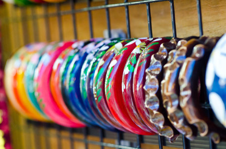Rows of colorful hand-made wooden bracelets - shallow DOF.