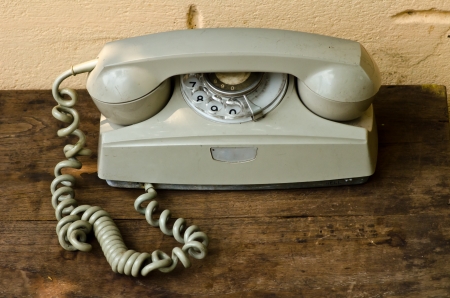 Vintage telephone on old table sepia photoの写真素材