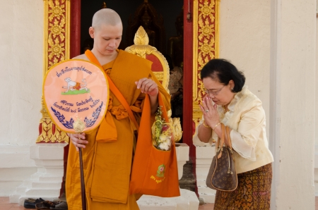 The old lady giving money to new monk in Buddhist ordination ceremony, Lopburi, Thailandのeditorial素材