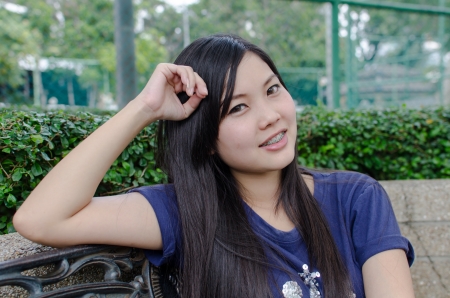 An Asian girl who is waiting in a gardenの写真素材