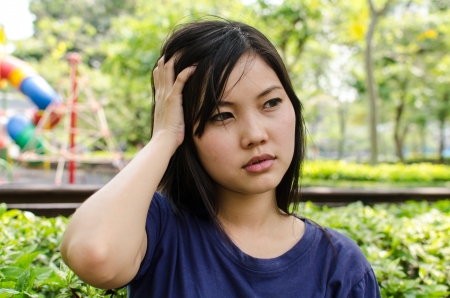 Lovely Chinese girl thinking in the gradenの写真素材