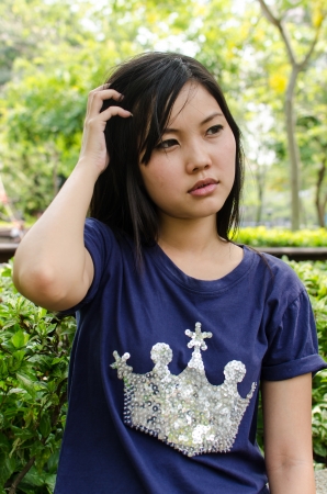 Lovely Chinese girl thinking in the gradenの写真素材