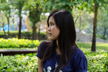 An Asian girl who is waiting in a gardenの写真素材