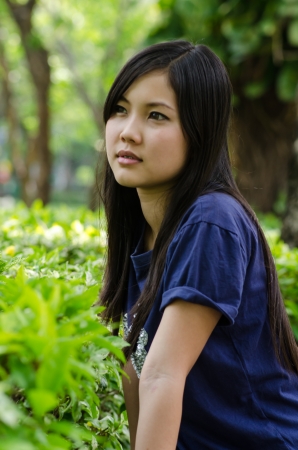 An Asian girl who is waiting in a gardenの写真素材