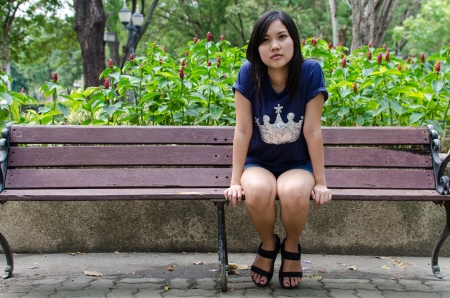 An Asian girl who is waiting in a gardenの写真素材