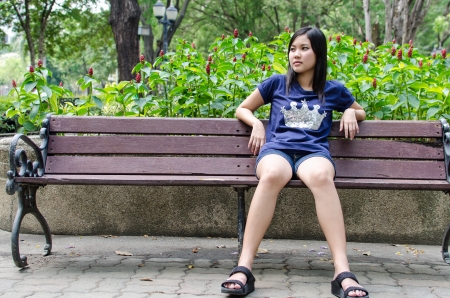 An Asian girl who is waiting in a gardenの写真素材