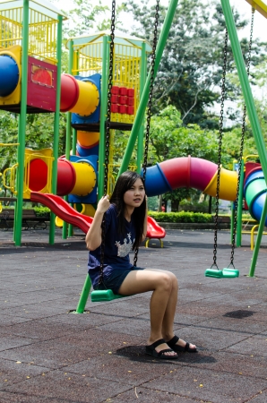 Lovely Chinese girl on the swing in the gradenの写真素材