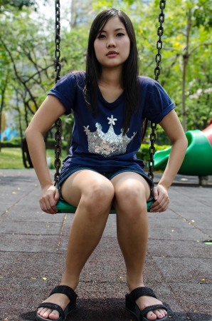 Lovely Chinese girl on the swing in the gradenの写真素材