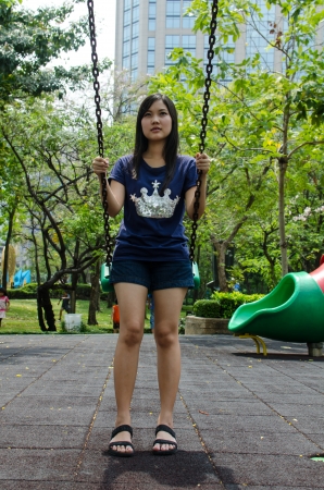 Lovely Chinese girl on the swing in the gradenの写真素材
