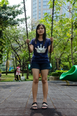 Lovely Chinese girl on the swing in the gradenの写真素材