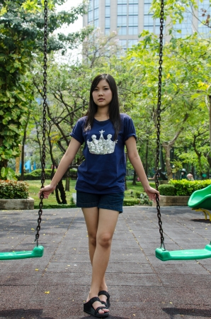 Lovely Chinese girl on the swing in the gradenの写真素材