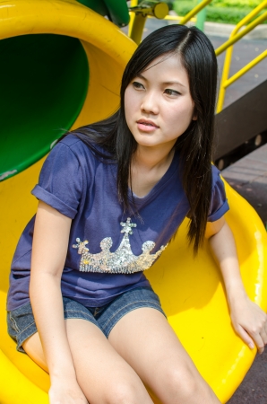 An Asian girl who is waiting in a gardenの写真素材