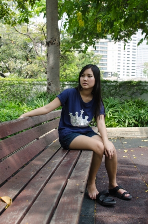 An Asian girl who is waiting in a gardenの写真素材