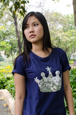 An Asian girl who is waiting in a gardenの写真素材