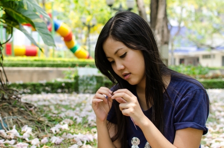 Lovely Chinese girl look at her hair in the gradenの写真素材