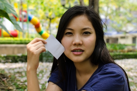 Lovely Chinese girl with blank card in the gradenの写真素材