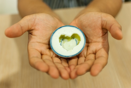 a coconut milk custard in small porcelain cup cut into the heart shapeの写真素材