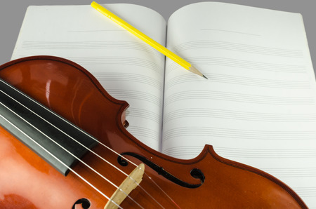 Closeup photo of violin and pencil on blank note sheetの写真素材