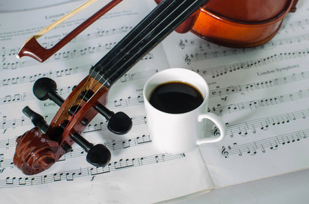 Closeup photo of violin and coffee on note sheet with text spaceの写真素材