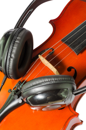 Artistic conceptual close-up of a pair of black headphones on a brown classical wooden violinの写真素材