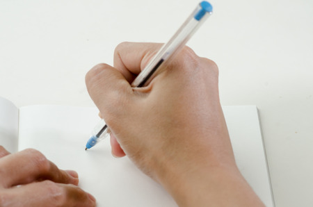 Close-up of a woman drawing into her diary by ballpoint penの写真素材