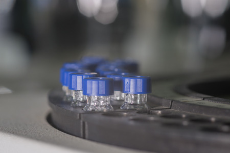 Sample vials in line waiting for analysis in front of light bokehの写真素材