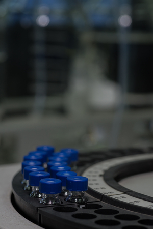 Sample vials in line waiting for analysis in front of light bokehの写真素材