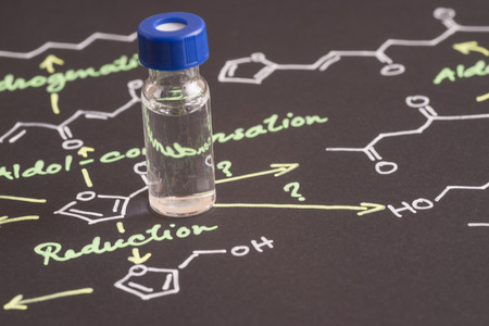 Close-up blue cap sample vial on paper with chemical formulaの写真素材