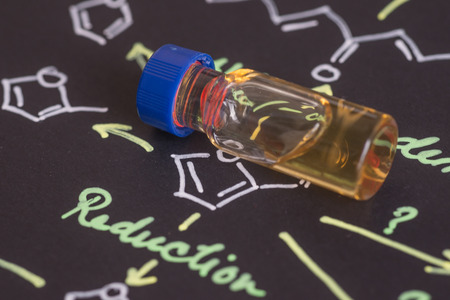 Close-up blue cap sample vial on paper with chemical formulaの写真素材