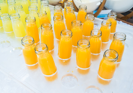 Fresh orange juice and pineapple juice in bottles glass.の写真素材
