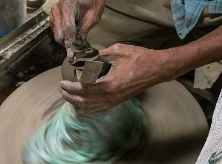 Hands working on pottery wheel.