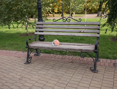 Wedding bouquet of roses on a wooden bench in the parkの写真素材