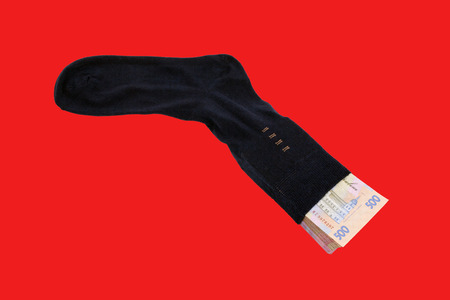 Stack Ukrainian Banknotes five hryvnia in black men's socks on a red backgroundの写真素材