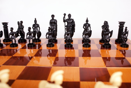 General view of black chess pieces on a chess board on a white backgroundの写真素材