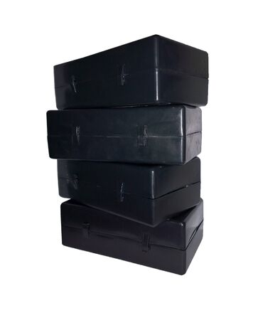Four black dirty plastic boxes stacked in a stack on a white backgroundの写真素材